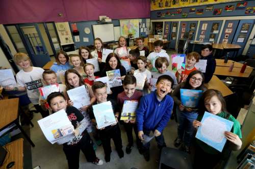 Brock Corydon grade 5 and 6 teacher Susan Pereles (back row, centre) with her class of students who show off their tourism guide for Winnipeg, called Better Known as Winnerpeg. (Ruth Bonneville / Winnipeg Free Press)