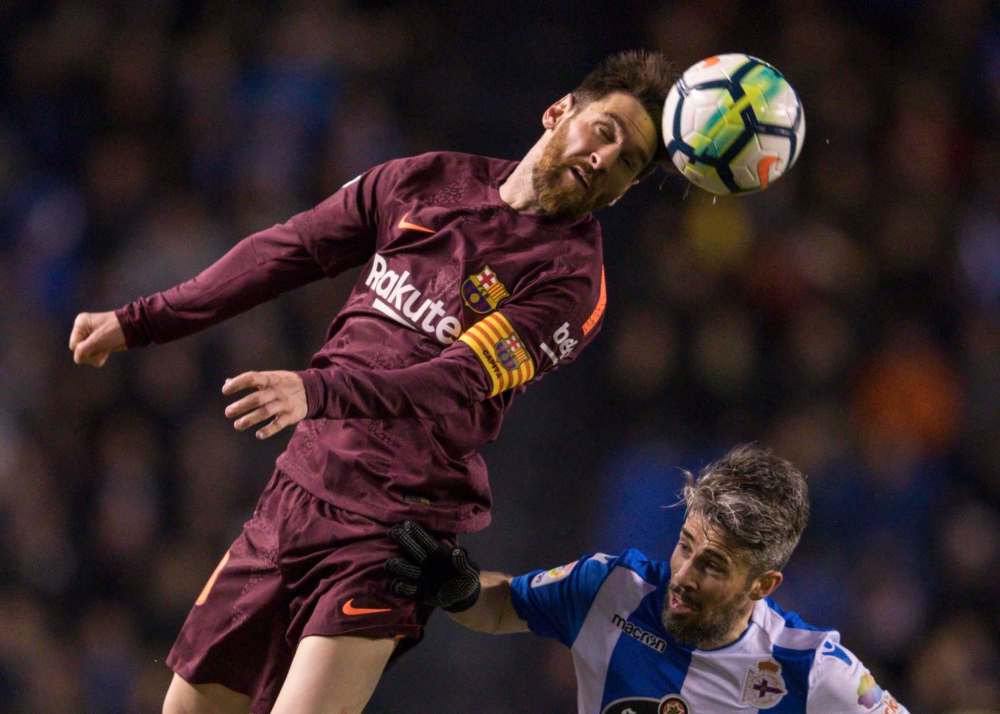 Lalo R. Villar / The Associated Press files
Barcelona’s Lionel Messi (left) challenges for the ball with Deportivo’s Luisinho. Messi’s side tackles Real Madrid in Sunday’s El Clásico.