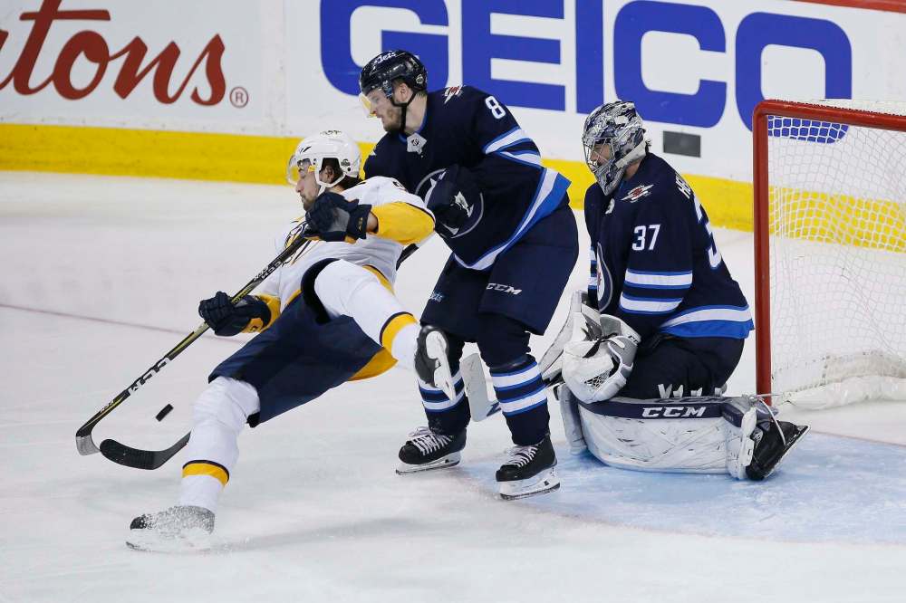 JOHN WOODS / THE CANADIAN PRESS FILES
Jets defenceman Jacob Trouba (centre) greets Predators forward Filip Forsberg on goalie Connor Hellebuyck’s doorstep in NHL playoff action last week. Trouba and partner Josh Morrissey are playing key playoff minutes.