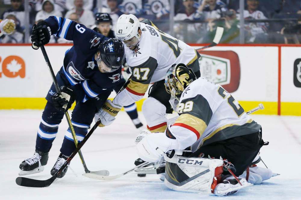 Vegas Golden Knights' goaltender Marc-Andre Fleury (29) knocks the puck away from Winnipeg Jets' Andrew Copp (9) as Knights' Luca Sbisa (47) defends during second period of game one action in the NHL Western Conference Final in Winnipeg on Saturday, May 12, 2018. THE CANADIAN PRESS/John Woods