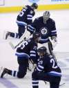 Trevor Hagan / The Canadian Press
The Jets take a knee on the ice after their loss on Sunday.