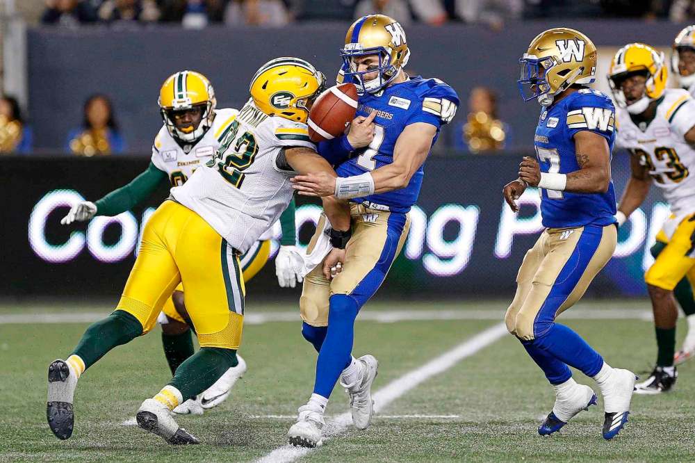 THE CANADIAN PRESS/John Woods
Winnipeg Blue Bombers quarterback Chris Streveler fumbles the ball after getting hit by Edmonton Eskimos' Brandon Pittman during the second half Friday. The fumble happened after Steveler scrambled for a 20-yard gain and was one the only blemish of a successful game for the backup QB.
