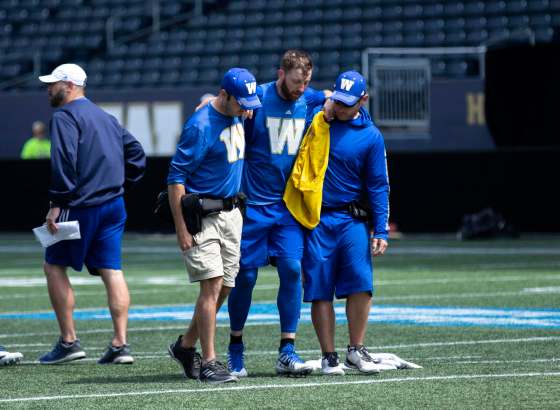 ANDREW RYAN / WINNIPEG FREE PRESSWinnipeg Blue Bombers Quarterback Matt Nichols is helped off the field after an injury during practice on Wednesday.