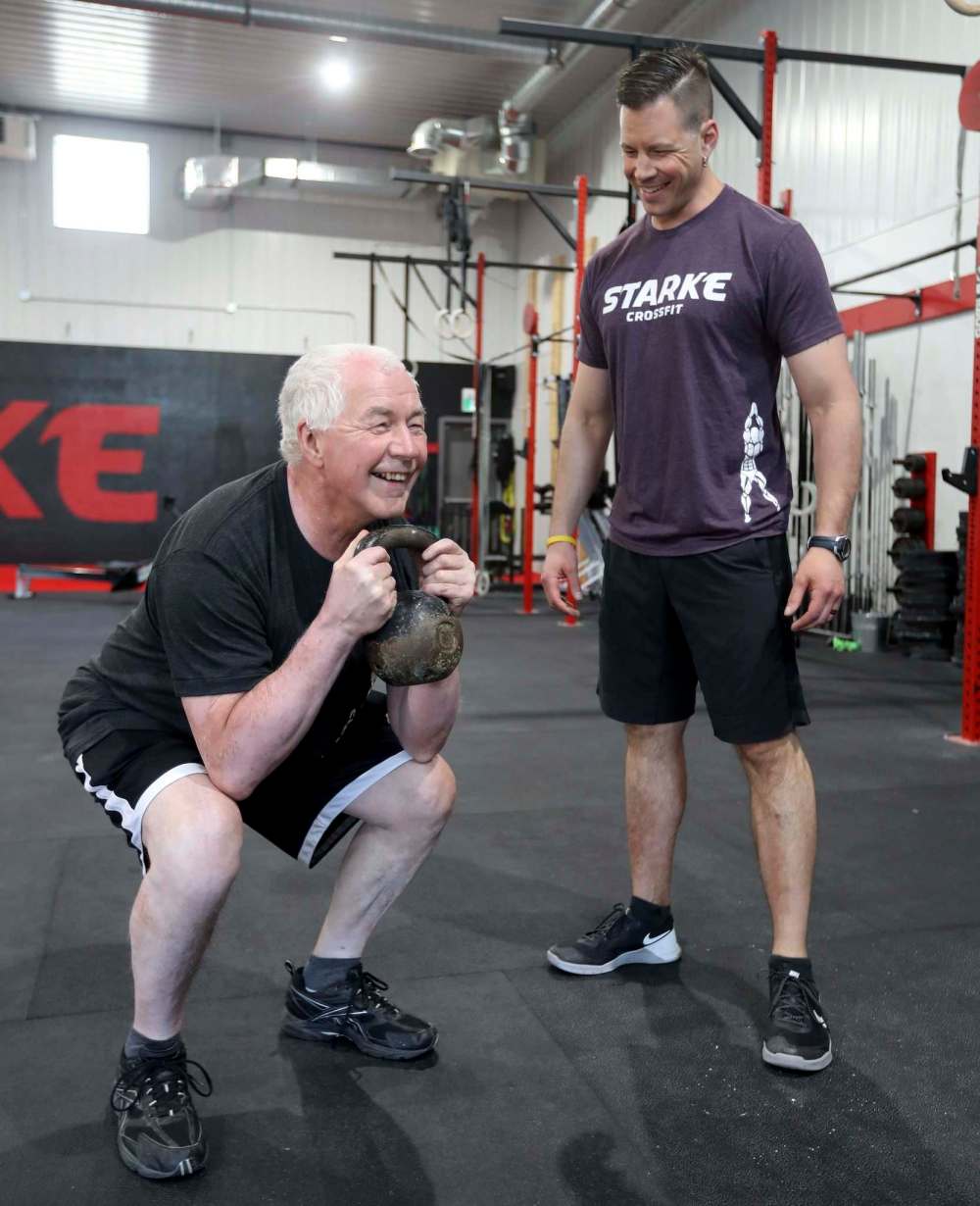 TREVOR HAGAN / WINNIPEG FREE PRESS
Personal trainer Paul Dyck helps his father, Lorne Dyck, exercise at Starke CrossFit.