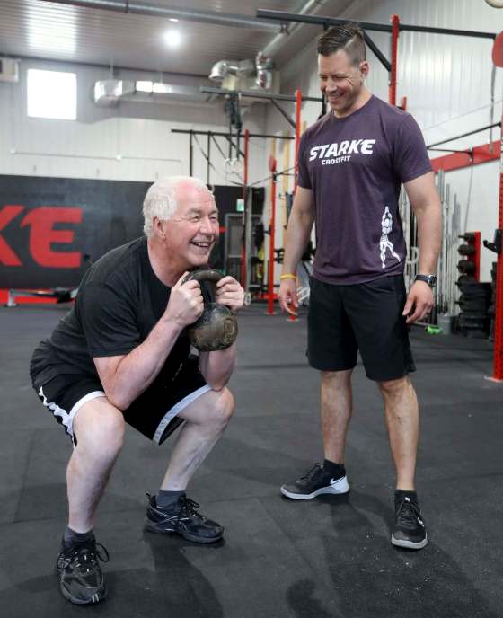 TREVOR HAGAN / WINNIPEG FREE PRESSPersonal trainer Paul Dyck helps his father, Lorne Dyck, exercise at Starke CrossFit.