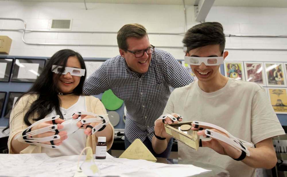 ERIK PINDERA / WINNIPEG FREE PRESS
Sisler High School teacher Jamie Leduc watches Denise Diosana (left) and Marcelo Aiello as they try to grab salt shakers with vision-impairing glasses and dexterity-reducing gloves.
