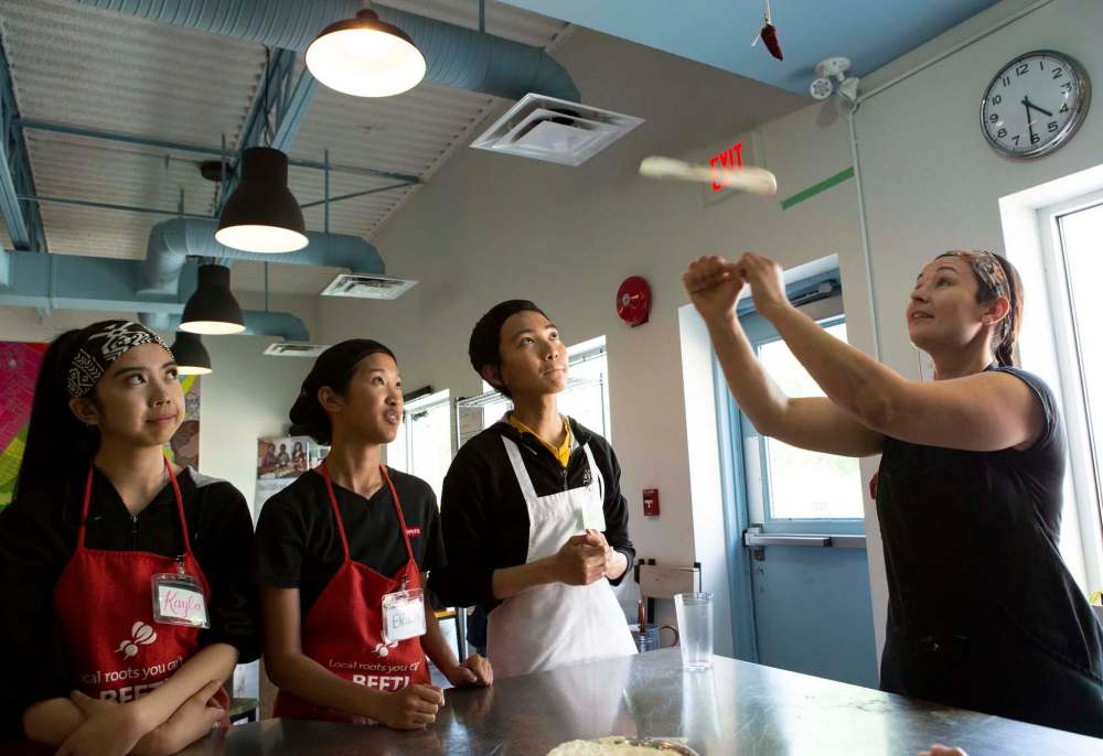 Metcalf tosses the pizza dough.