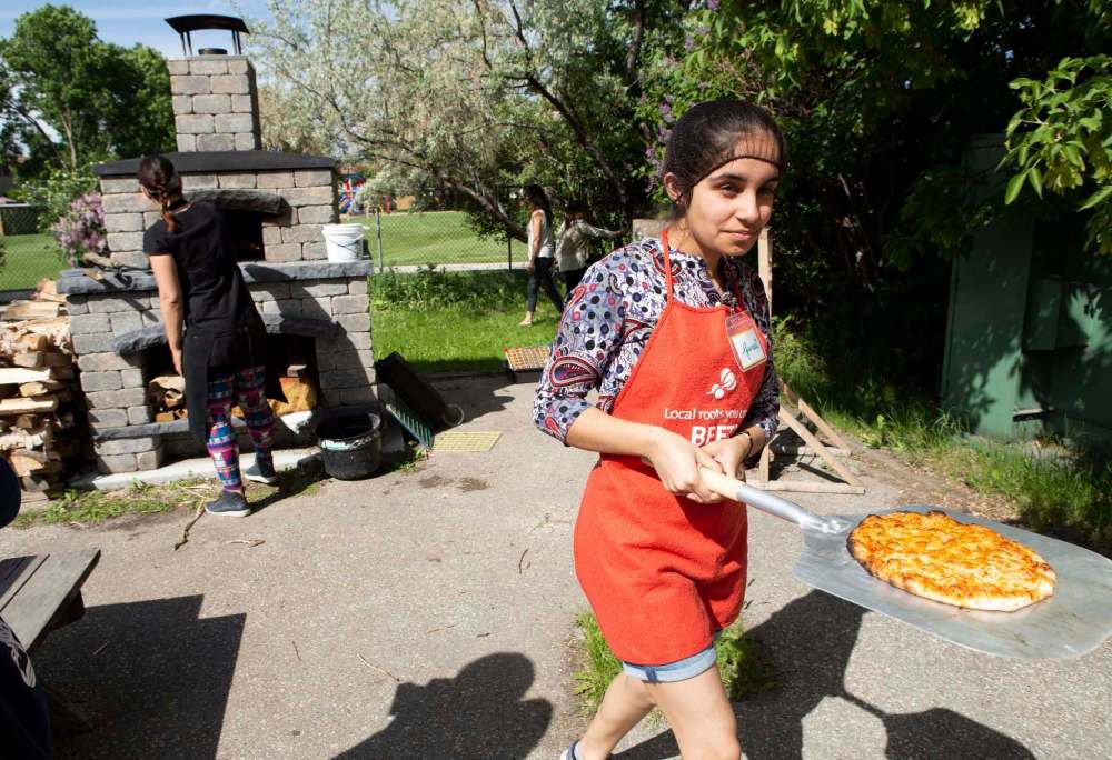 Guneet Uppal walks the first of the pizza from the oven.