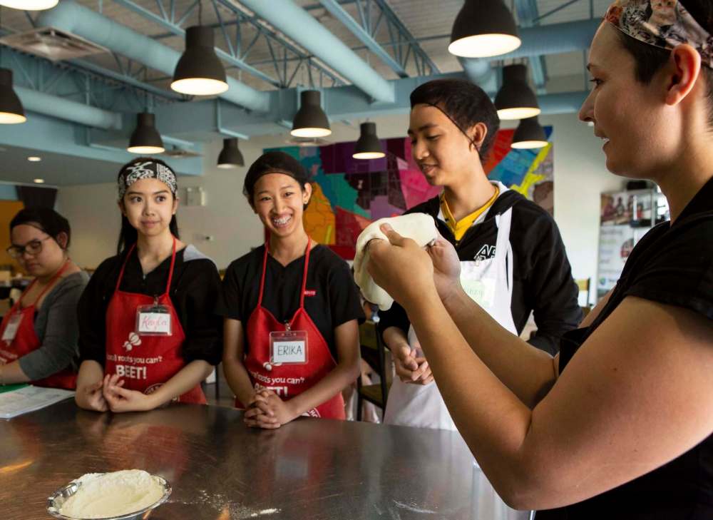 Camille Metcalf (left) gets ready to demonstrate how to toss pizza dough.