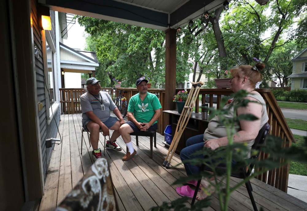 RUTH BONNEVILLE / WINNIPEG FREE PRESS
Tenants Wayne Meeches (from left), Riley Evans, and Debby Sillito sit on the front porch and chat.