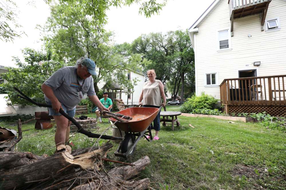 RUTH BONNEVILLE / WINNIPEG FREE PRESS
Tenants Debby Sillito and Wayne Meeches sort out wood for the backyard fire pit as fellow tenant Riley Evans (green shirt), looks on.