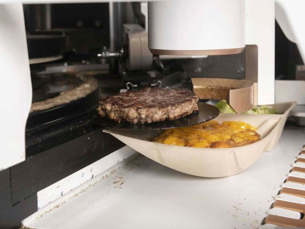 A freshly cooked burger exits the machine at the Creator storefront in San Francisco, California, U.S., on Monday, June 18, 2018. On June 27, the world’s first robot-crafted burger will roll off a conveyor belt in San Francisco and into the hands of the public. The product, from Bay Area-based Creator, a culinary robotics company, is assembled and cooked in a machine that contains 20 computers, 350 sensors, and 50 actuator mechanisms. Photographer: Cayce Clifford/Bloomberg