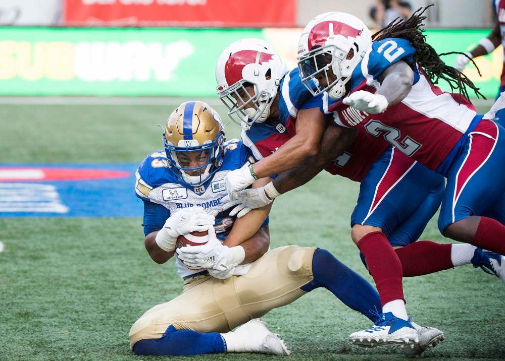 Andrew Harris, left, goes in for a touchdown against the Montreal Alouettes Friday night. (Graham Hughes / Canadian Press files)