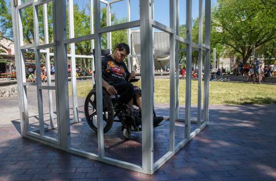 Tyson Sylvester, 22, put himself in a mock jail cell Thursday in Old Market Square to demonstrate what it's like to live in isolation as a person with a disability. (Mike Deal / Winnipeg Free Press)