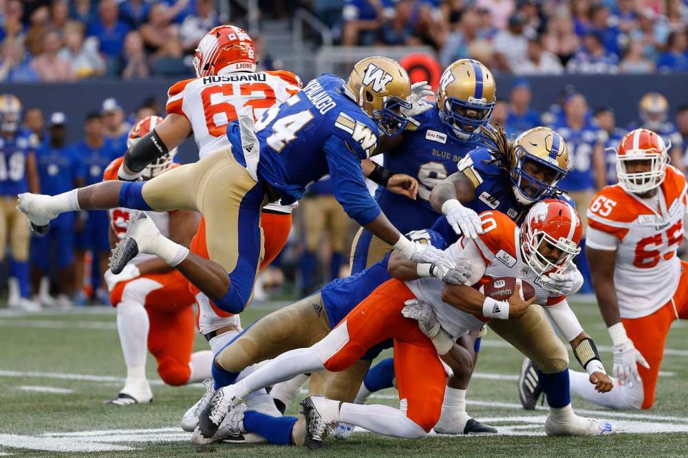JOHN WOODS / THE CANADIAN PRESS FILES
Winnipeg Blue Bombers' Jackson Jeffcoat (94) and Cory Johnson (67) sack BC Lions quarterback Jonathon Jennings (10) as Bombers' Tristan Okpalaugo (54) leaps over during the first half of CFL action in Winnipeg Saturday, July 7, 2018.