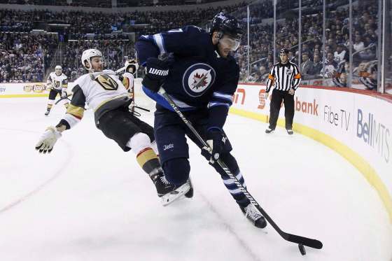 John Woods / The Canadian Press FilesWinnipeg Jets' Adam Lowry wins a puck battle against Vegas Golden Knights' Colin Miller. The Jets big-bodied fourth-line centre has signed a new contract to keep him Winnipeg for the next three seasons.