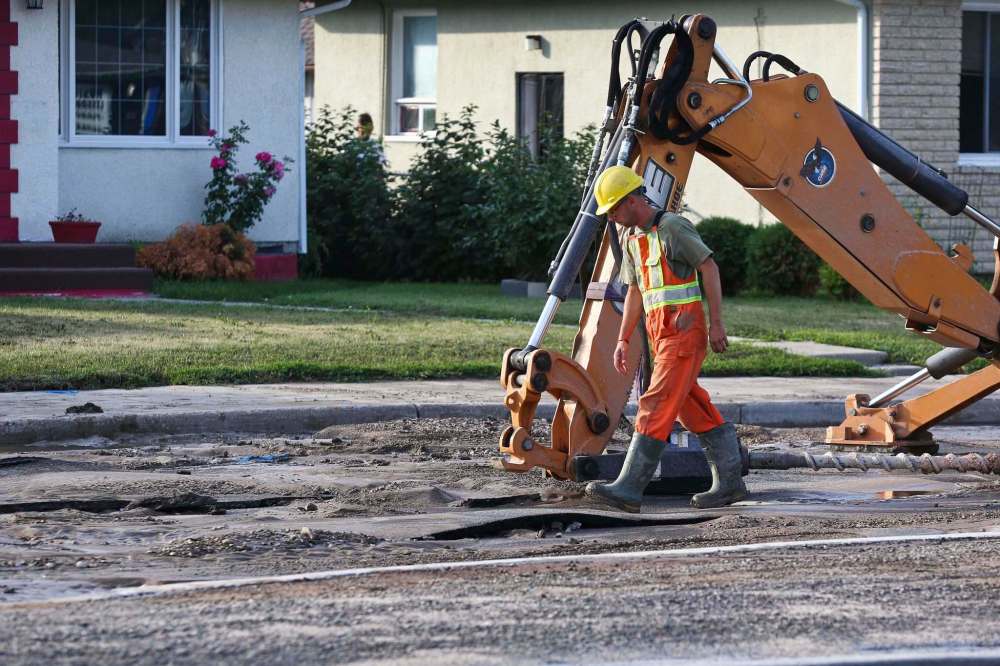(Mike Deal / Winnipeg Free Press)
A Winnipeg Water Services crew gets ready to drill holes in the northbound lanes of McPhillips Street between College Avenue and Redwood Avenue Monday morning after a severe water main break buckled the pavement.