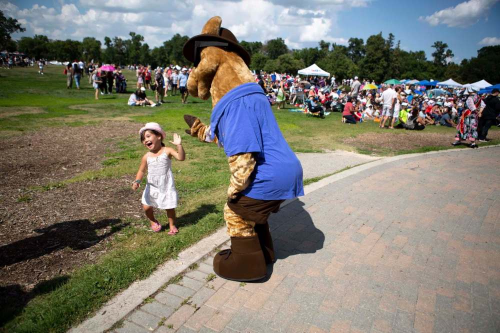 ANDREW RYAN / WINNIPEG FREE PRESS
Sienna Solano, 4, runs away in joyful terror as she high-fives reporter Jen Zoratti posing as the Folklorama Llama.