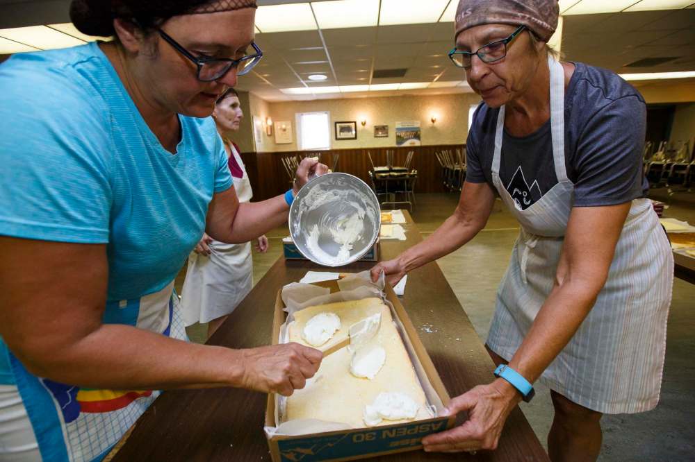 MIKE DEAL / WINNIPEG FREE PRESS
Hilda Terry (left) and Alenia Howell add a final layer of cream filling to the lemon torte.