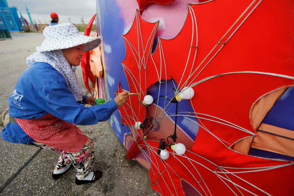 Liu Qiong Xian, a light artist, works on one of the displays earlier this month. (John Woods / Winnipeg Free Press)