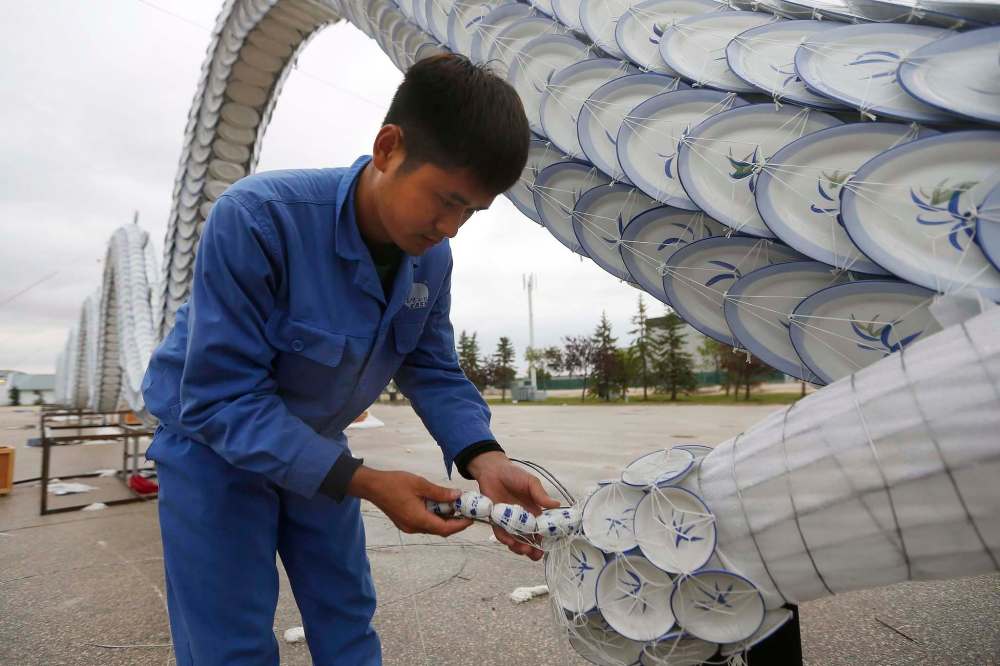 Jian Wang, a light artist at The Lights Of The North - Chinese Lantern Festival puts the finishing touches on a 37-metre dragon earlier this month. (John Woods / Winnipeg Free Press)