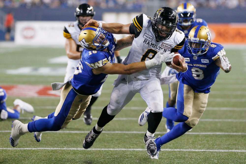Winnipeg Blue Bombers' Taylor Loffler (16) and Chris Randle (8) chase down Hamilton Tiger-Cats' quarterback Jeremiah Masoli (8) as he drives for the touchdown line during the second half of CFL action in Winnipeg on Friday. (John Woods / The Canadian Press)