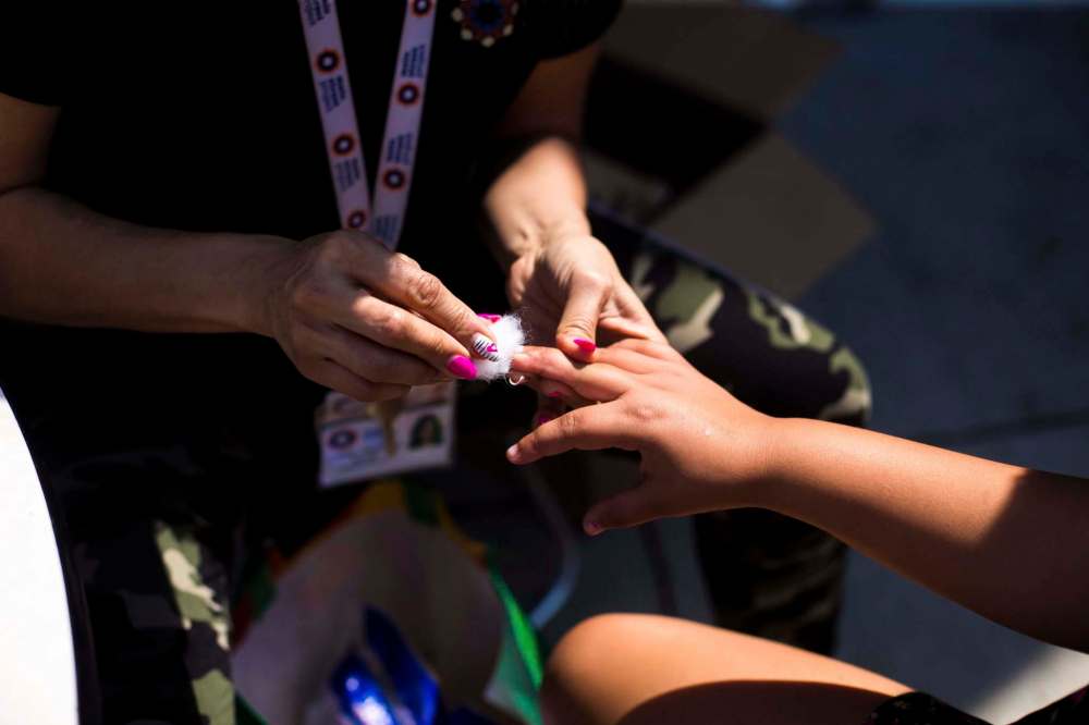 MIKAELA MACKENZIE / WINNIPEG FREE PRESS
Page Longbottom gets her nails done by Jane Warkola at a pickup street hockey game and barbecue hosted by the Main Street Project Wednesday.