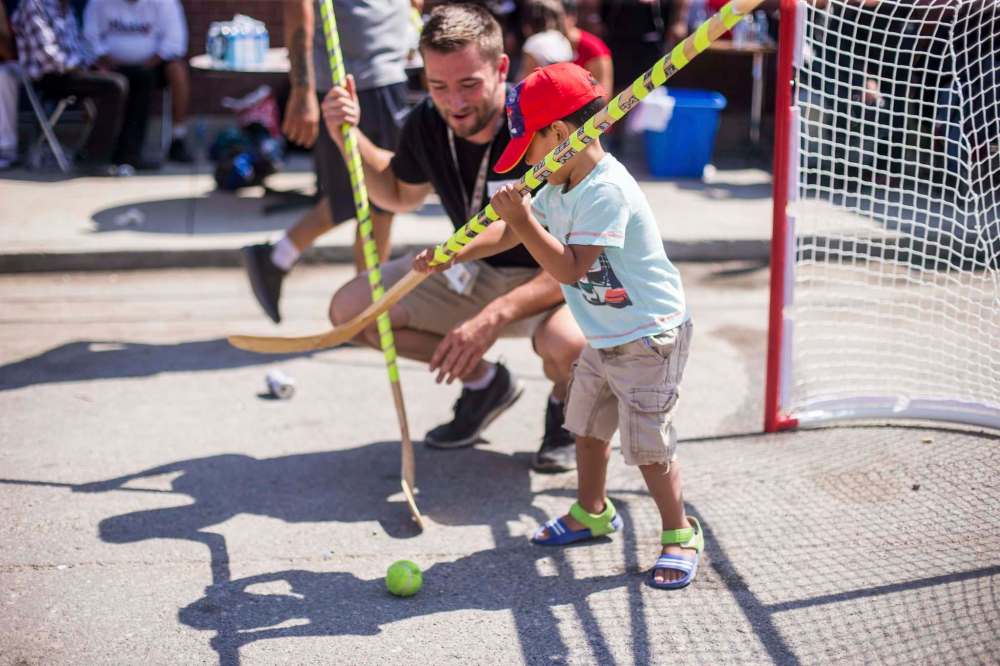 MIKAELA MACKENZIE / WINNIPEG FREE PRESS
Main Street Project summer student specialist Carter Bergen helps Jace McKay, 3, play.