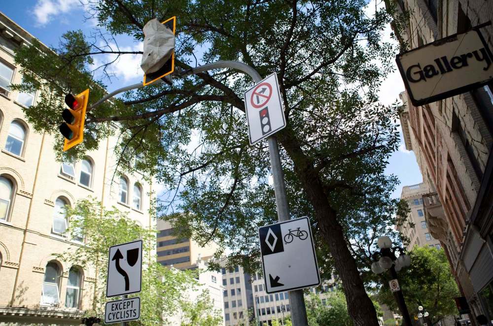 ANDREW RYAN / WINNIPEG FREE PRESS Newly installed signage and traffic lights regulating traffic to protect bicyclists along McDermot Avenue in the Exchange district on August 21, 2018.