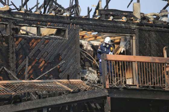 TREVOR HAGAN / WINNIPEG FREE PRESSAn investigator from the fire department takes photos on the third floor at the scene of a fire at the corner of Vermillion Road and Grover Hills Lane on Sunday after an apartment block was gutted in an early-morning blaze.