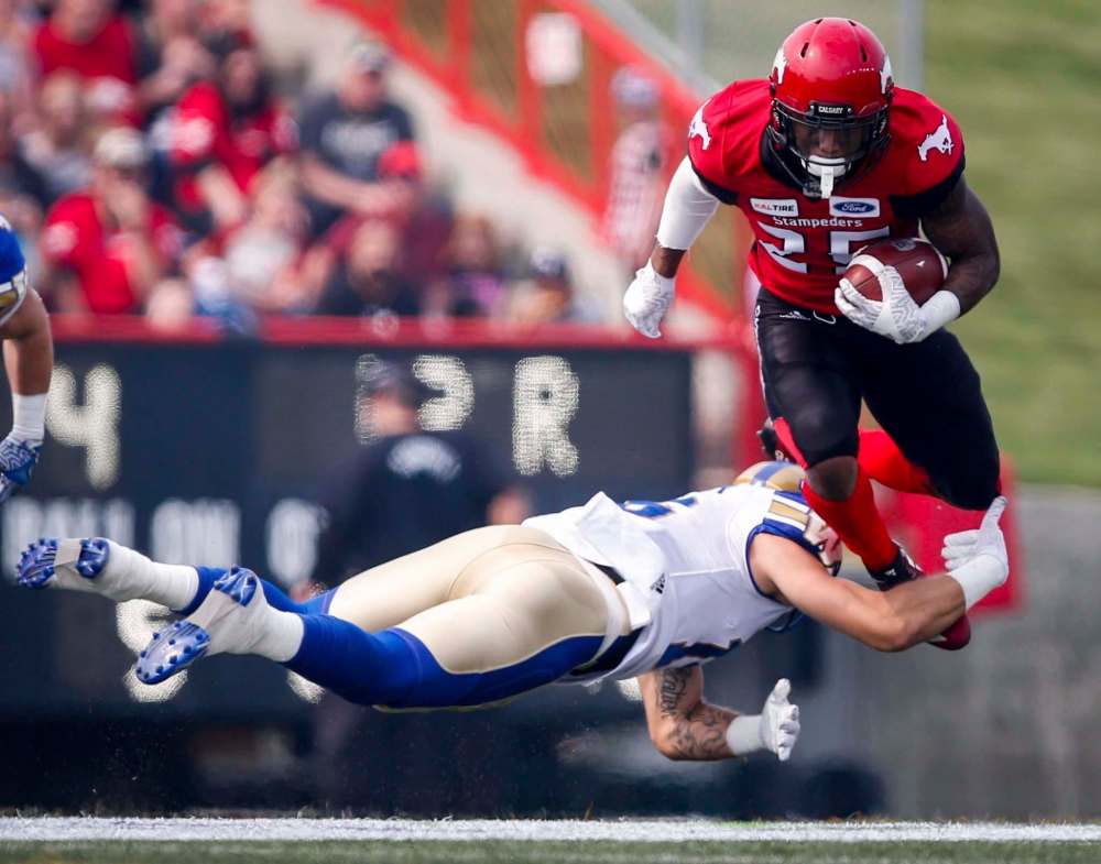 JEFF MCINTOSH / THE CANADIAN PRESS
Blue Bombers defensive back Taylor Loffler tackles Calgary Stampeders running back Don Jackson during CFL play Saturday in Calgary. The Bombers lost their second straight game in a 39-26 final.
