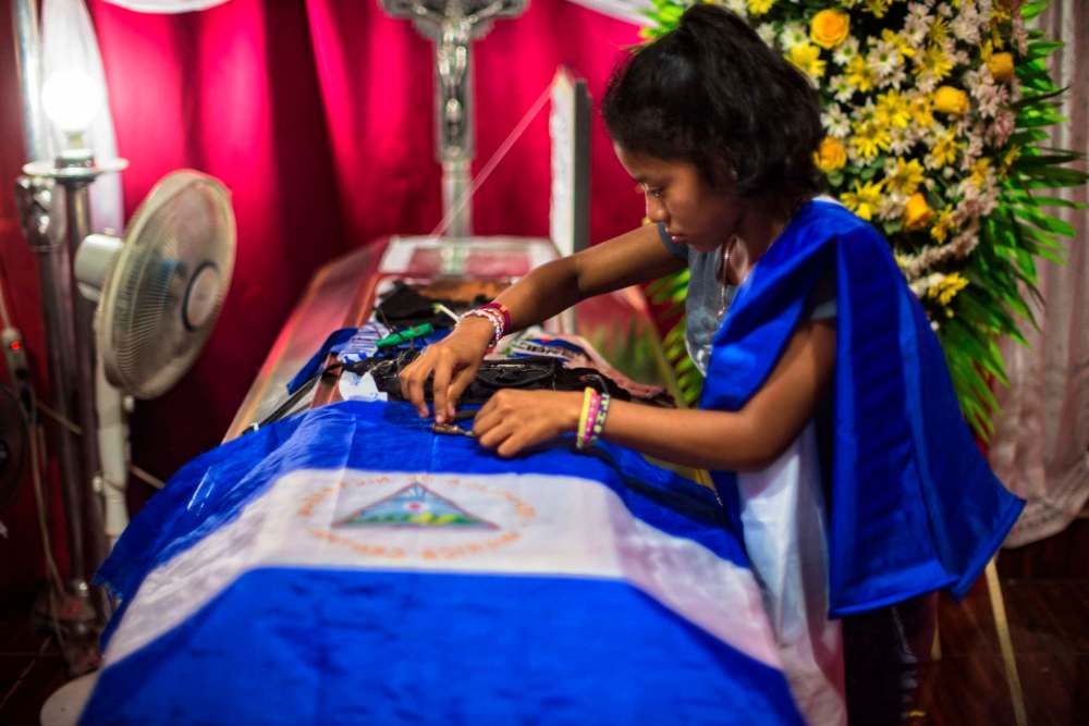 Juan Carlos / for the Washington Post
Paola arranges bullet shells on the coffin of her brother Gerald Jose Vasquez Lopez, 20. He was killed during a standoff with police and pro-Ortega paramilitaries at the National Autonomous University of Nicaragua in Managua on July 14.