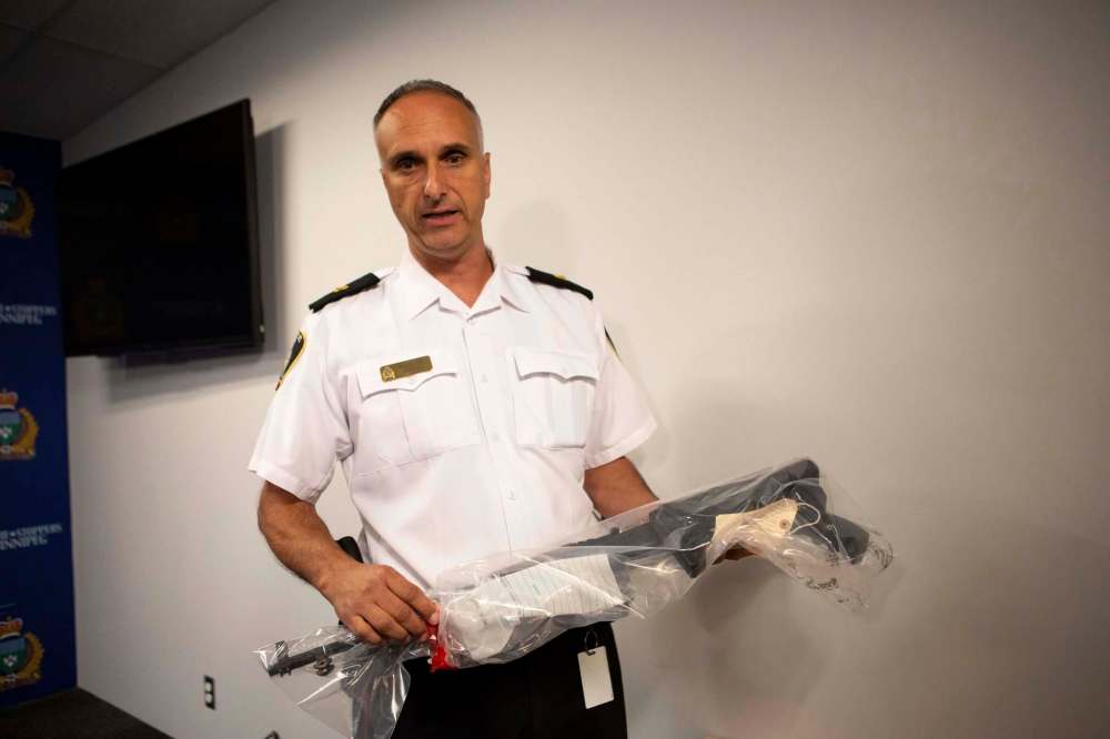 Winnipeg Police Insp. Max Waddell presents a SKS rifle which was seized. (Andrew Ryan / Winnipeg Free Press)