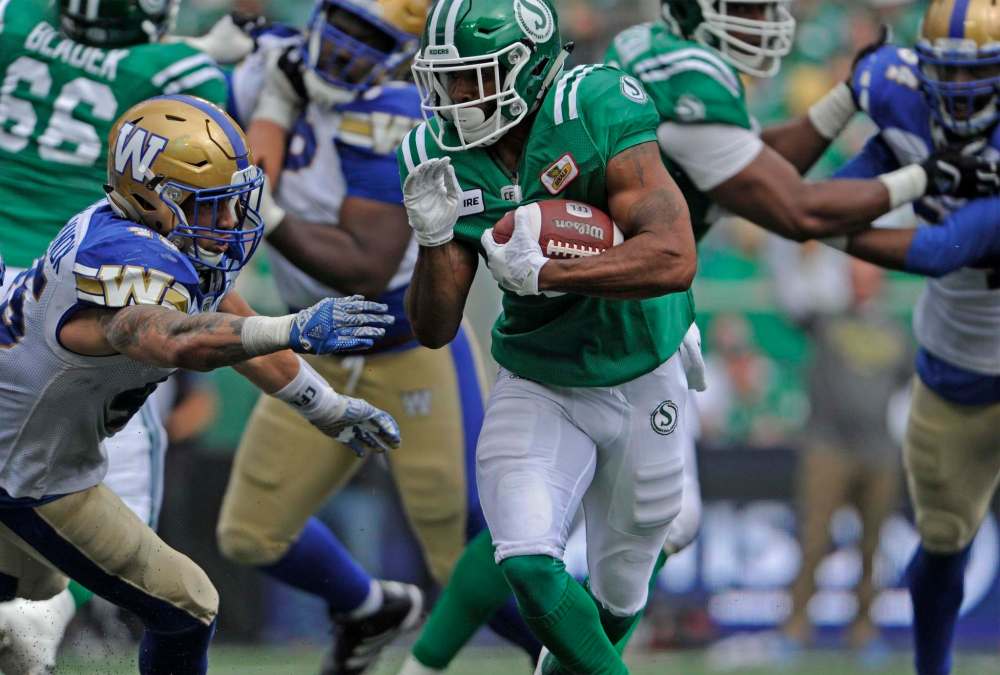 MARK TAYLOR / THE CANADIAN PRESS
Saskatchewan Roughriders running back Marcus Thigpen muscles through a crowd during second half Labour Day CFL action against the Winnipeg Blue Bombers, at Mosaic Stadium in Regina on Sunday, Sept. 2, 2018.