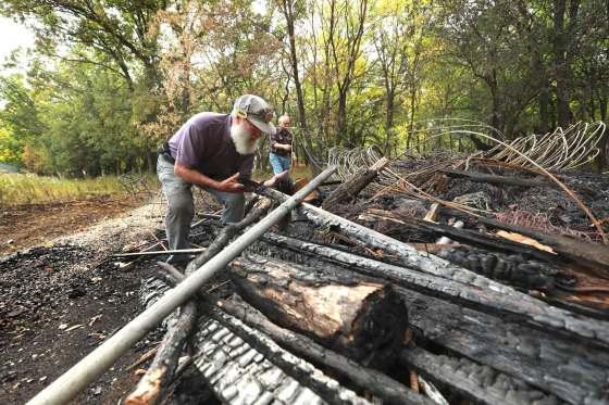 Assiniboine Valley Railway president Len LaRue (left) and AVR member Vic St. Germain clean up after a shed housing custom-made dinner tabletops and Christmas decorations burned down in what railway members believe was a deliberately set fire. (Ruth Bonneville / Winnipeg Free Press)