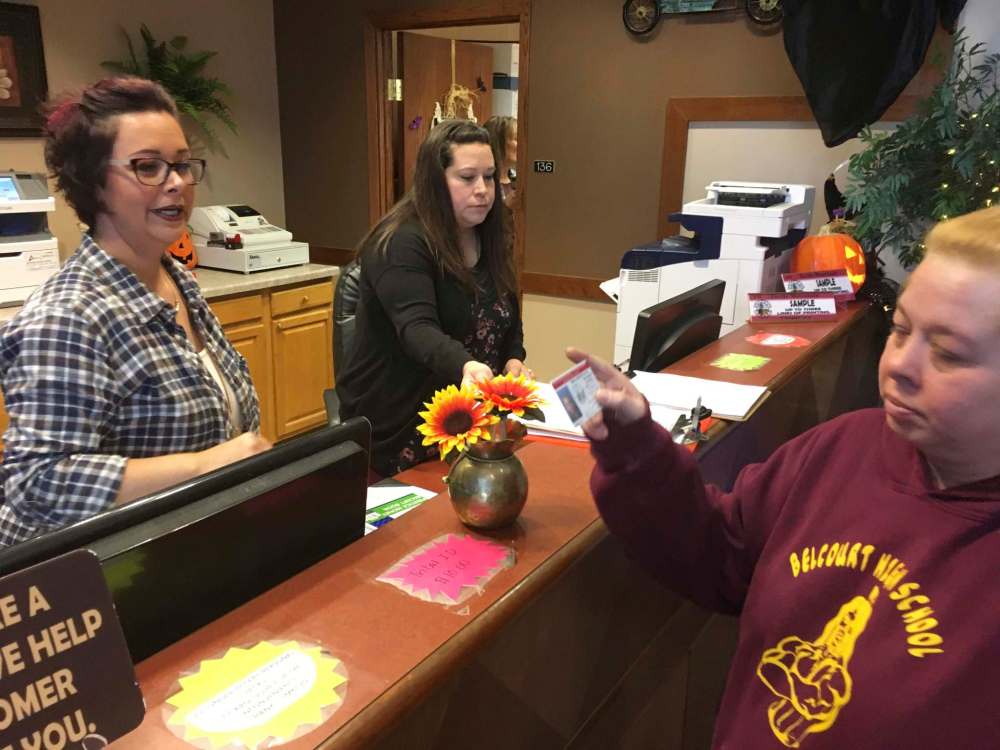 Delaine Belgard (right) shows the new Turtle Mountain Band of Chippewa ID she received free of charge on Wednesday, in Belcourt, N.D. It will allow her to vote in November under recently tightened state voter ID rules. (AP Photo/Blake Nicholson)