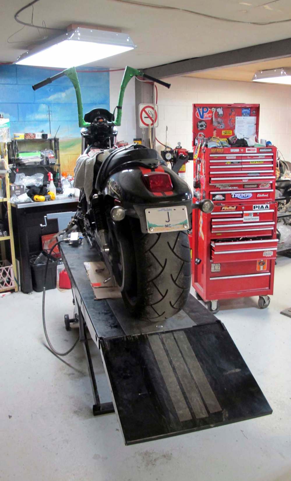 A custom Harley-Davidson with new handlebars on a motorcycle lift at Prairie Iron Motorworks.