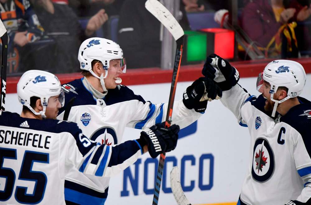Patrik Laine celebrates a goal with Mark Scheifele (55) and Blake Wheeler in Helsinki, Finland last week. (Martti Kainulainen / Lehtikuva files)