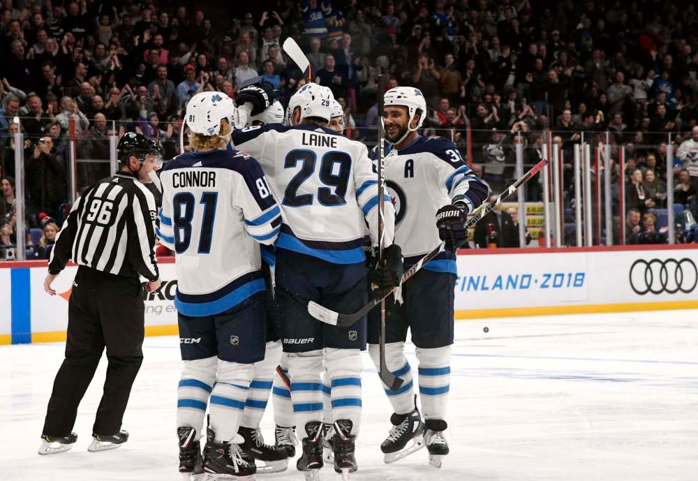 Patrik Laine celebrates with his team after scoring the Jets third goal during the third period against the Panthers in Helsinki, Finland. (Martti Kainulainen / Lehtikuva via the Associated Press)