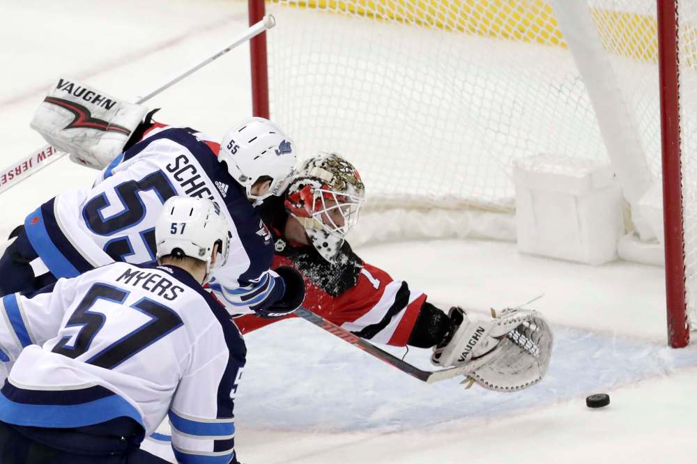 Mark Scheifele beats New Jersey Devils goaltender Keith Kinkaid in overtime on Saturday. (Julio Cortez / The Associated Press files)