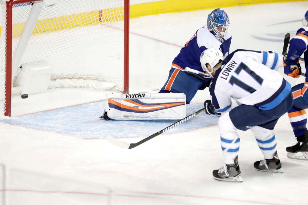 Adam Lowry got the game winner Tuesday against the New York Islanders 22 seconds after Jacob Trouba got the Jets on the board. (Julio Cortez / The Associated Press)