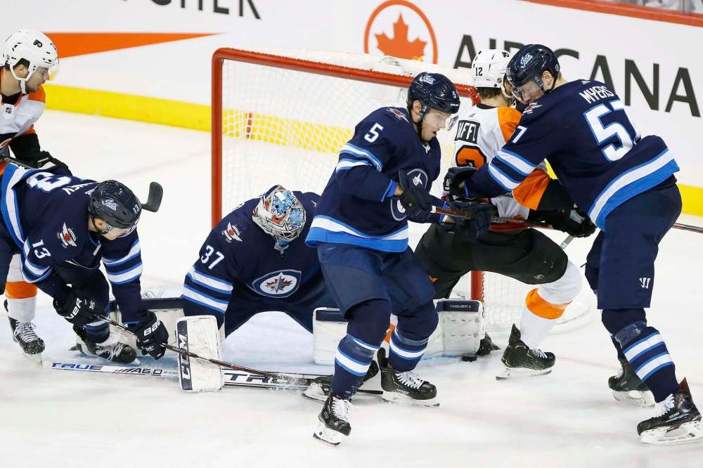 JOHN WOODS / WINNIPEG FREE PRESS
Winnipeg Jets goaltender Connor Hellebuyck (37) saves the shot from Philadelphia Flyers' Michael Raffl (12) as Jets' Dmitry Kulikov (5) and Tyler Myers (57) defend during second period NHL action in Winnipeg on Sunday.