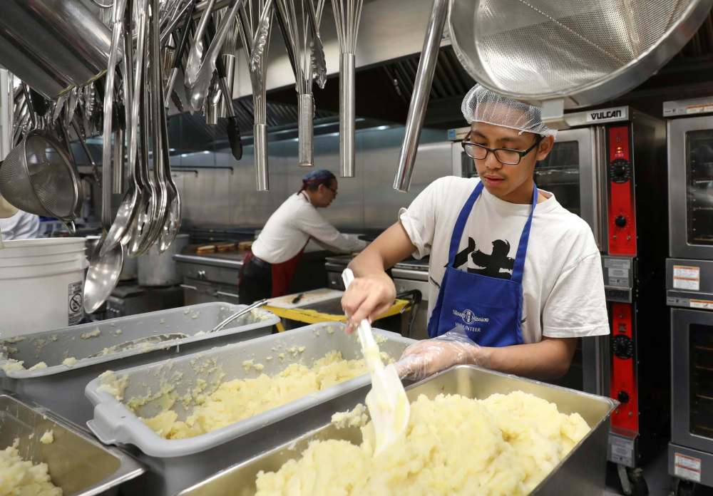 PHOTOS BY RUTH BONNEVILLE / WINNIPEG FREE PRESS
At Siloam Mission, 125 volunteers will help serve breakfast, lunch and dinner on Christmas Eve. Above, Maples Collegiate student Amiel Ramos, scoops mashed potatoes in Siloam’s kitchen.