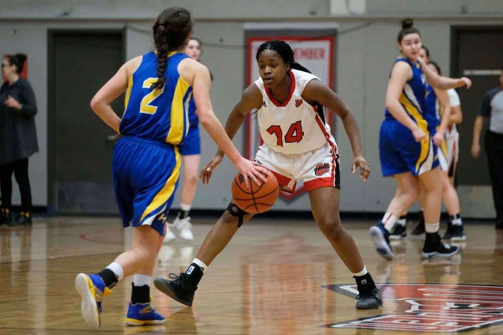 Winnipeg's Deborah Nkiasi (right) watches Okanagan's Vanessa Botteselle (left) Friday during the annual Wesmen Classic. (Daniel Crump / Winnipeg Free Press)