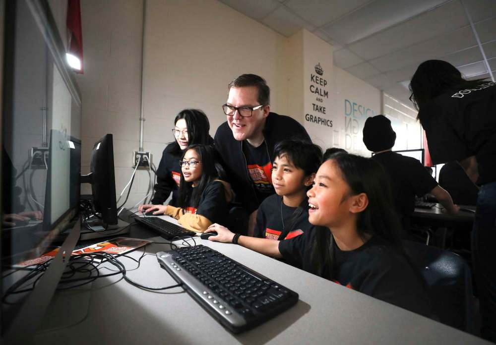 RUTH BONNEVILLE / WINNIPEG FREE PRESS
Jamie Leduc, head of the department of interactive digital media at Sisler High School, helps students Ayaiya Alibudbud (right) and Isabella Recuenco learn creative uses of technology during Game On, a two-day celebration of techno-creative skills for Manitoba students at Sisler High School.