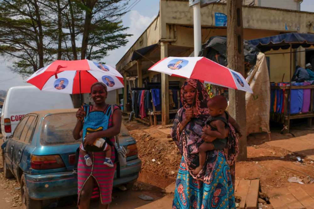 Siobhan O’Grady / washington post
Women in Yaoundé, Cameroon, carry umbrellas they received as campaign handouts featuring President Paul Biya, whose government forces have been criticized for reportedly attacking unarmed citizens in the country’s anglophone villages.