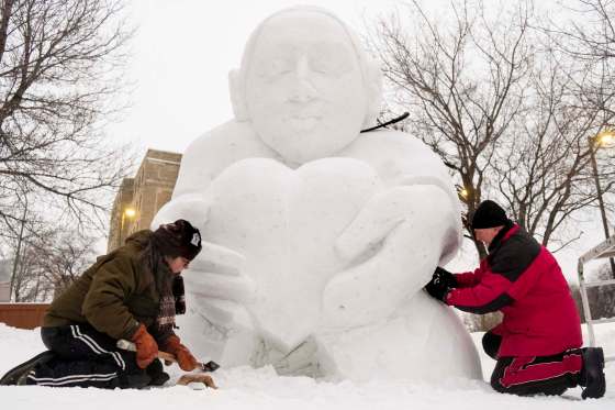 Madeleine Vrignon and Gary Tessier don't mind a bit of extra snow, which goes into the creation of their Festival du Voyageur sculpture. (Daniel Crump / Winnipeg Free Press files)