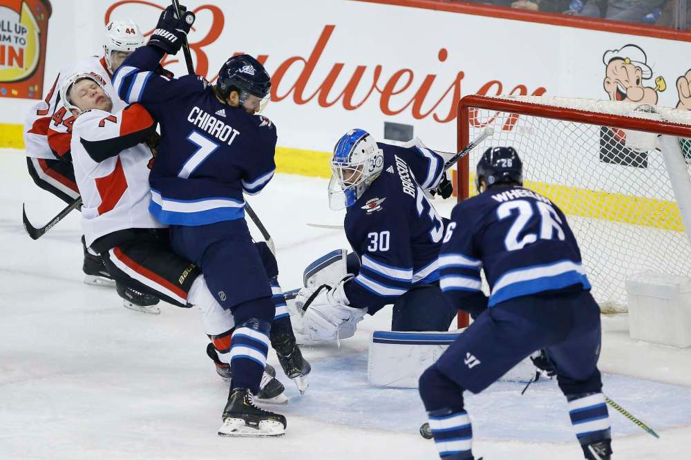 JOHN WOODS / THE CANADIAN PRESS
Winnipeg’s Ben Chiarot slams Ottawa’s Brady Tkachuk Saturday night at Bell MTS Place.