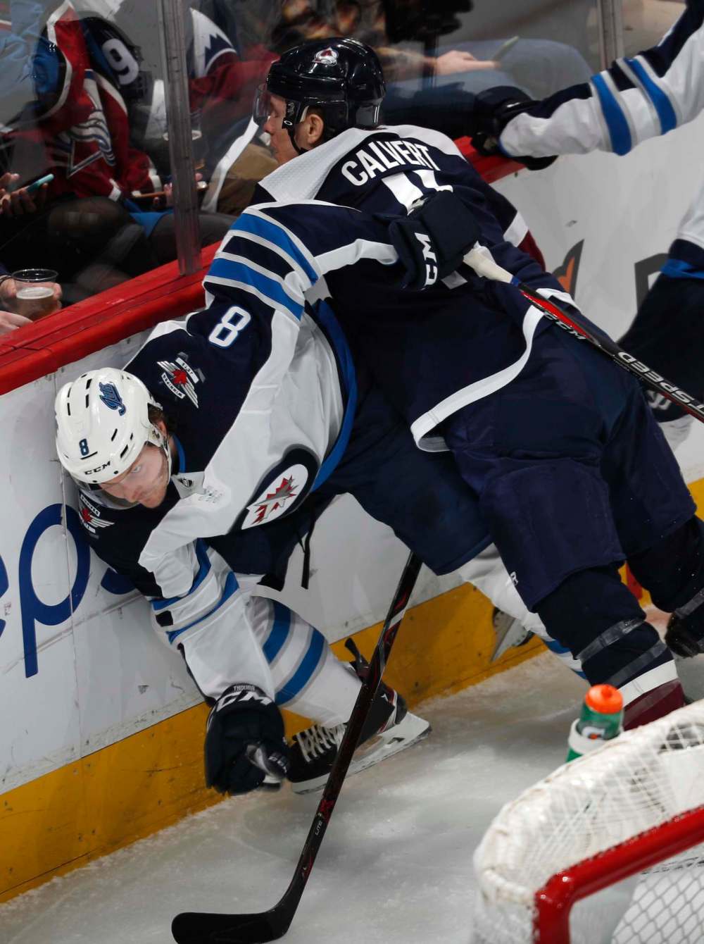 Avalanche left wing Matt Calvert checks defenceman Jacob Trouba.