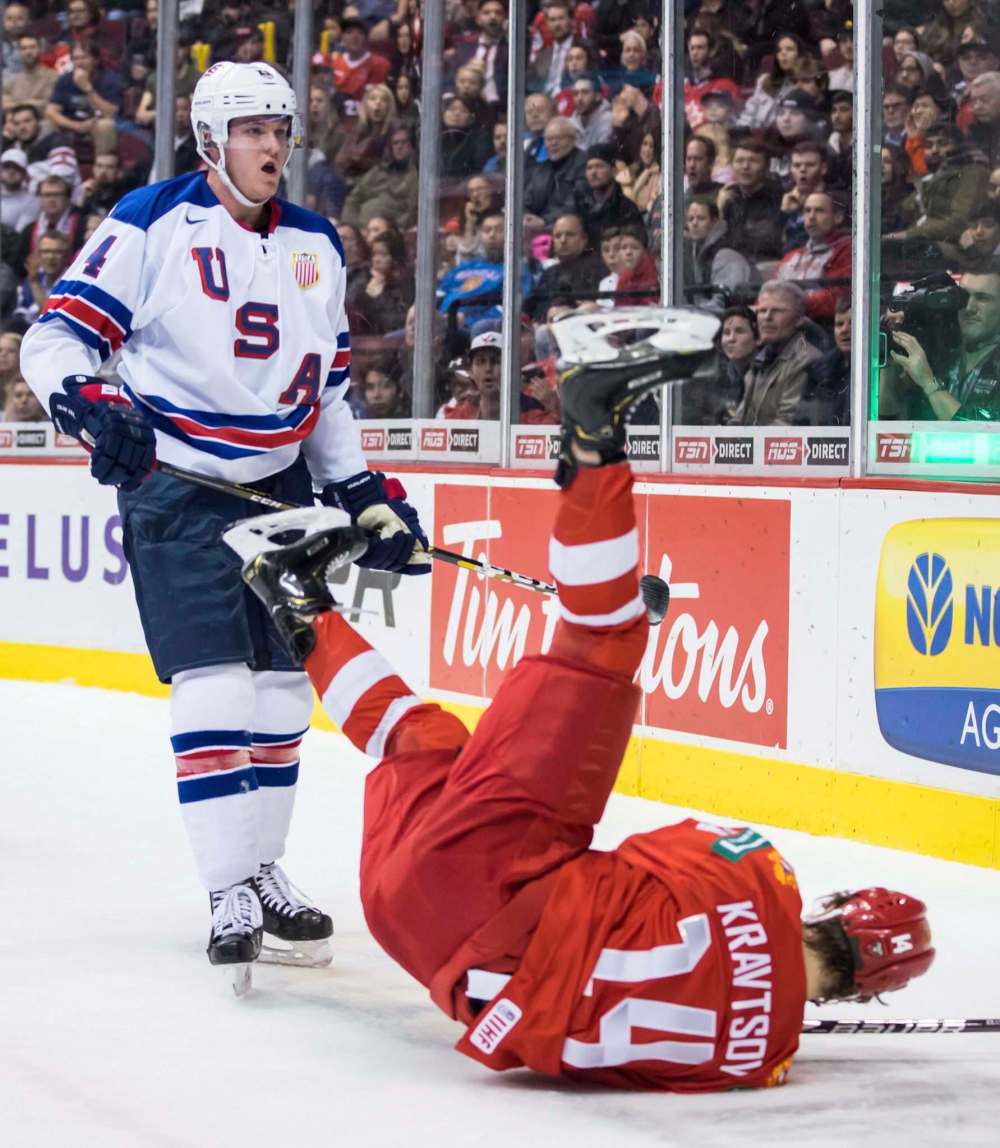 Darryl Dyck / The Canadian Press files
Jets prospect Dylan Samberg (left, upending Russia’s Vitali Kravtsov) is progressing in his second season of U.S. college hockey.